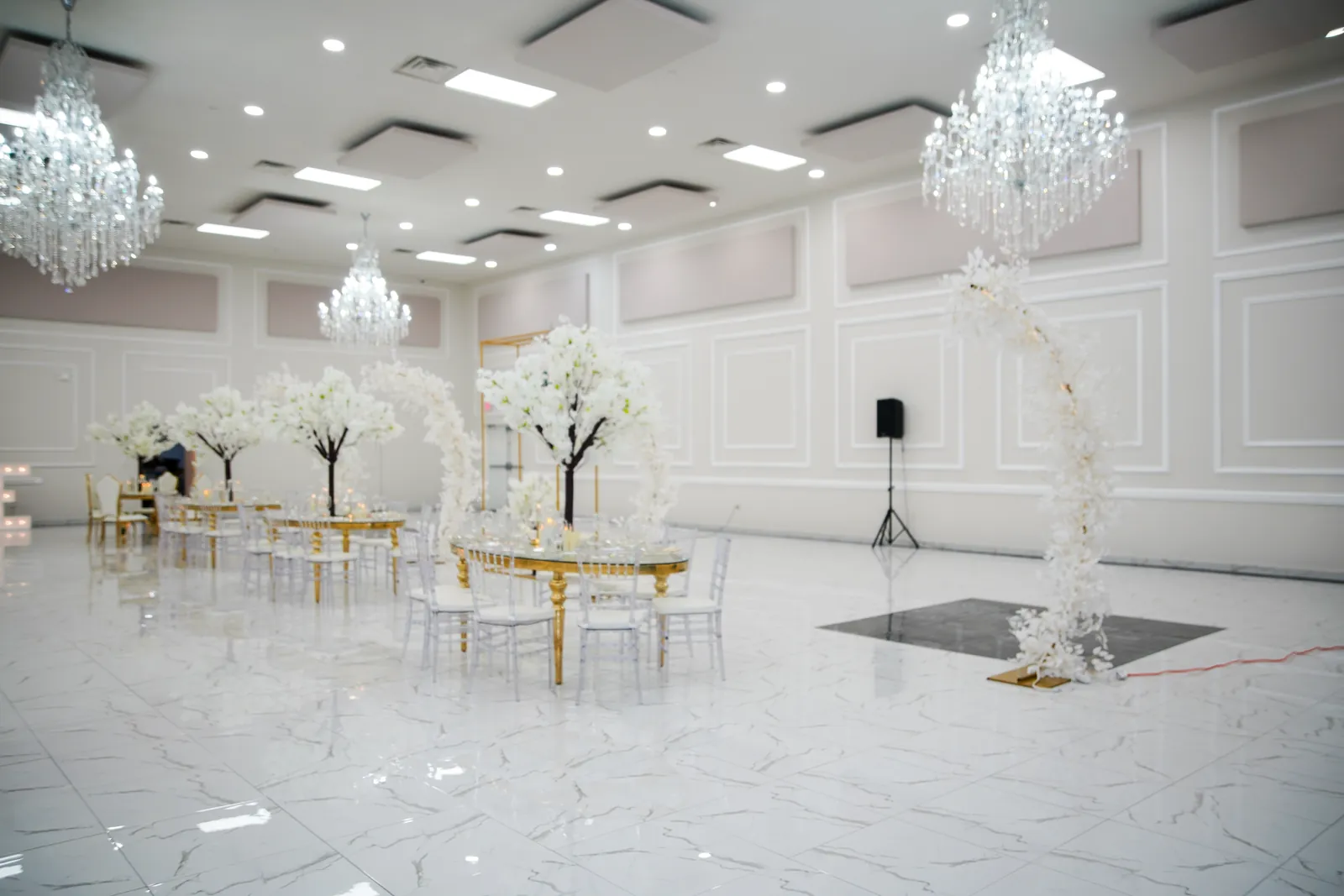 The hall set for a ceremony in white and gold
